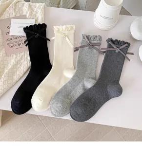 Detailaufnahme von Damen Socken mit süßen Schleifen, Knöpfen und Rüschenbündchen.