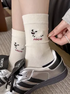 Detail view of women's cute cartoon sheep embroidered mid-calf cotton socks in beige.
