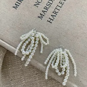 Pearl bow beaded shoe clip detail, elegant white tassel charm for stylish footwear accessories.