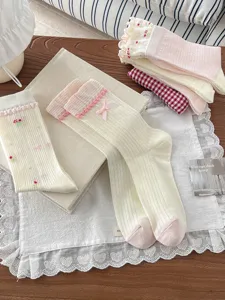 Detailed view of sweet Korean style mesh mid-tube socks with delicate lace trim and cute bows.