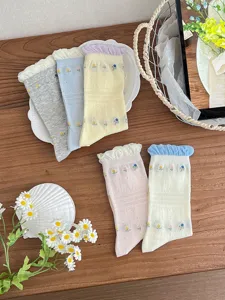 Primo piano di calzini con fiori e volant graziosi, cotone morbido e comodo per la primavera.
