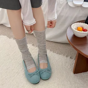 Detailansicht grauer Scrunch-Socken kombiniert mit süßen Ballerinas, bequemer Stoff.