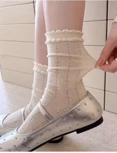 Chaussettes blanches à volants avec motif délicat et tissu élastique, gros plan détaillé.