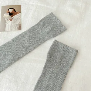 Nahaufnahme von grauen Rippstrick-Stegstulpen, weiche Textur, sommerlicher atmungsaktiver Stil.