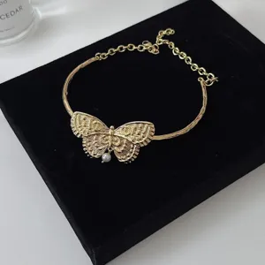 Gouden vlinder choker halsketting met parelhanger, vintage metalen sieraden detail