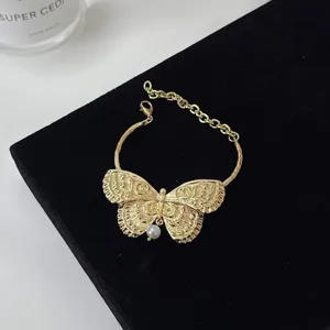 Detail van de vintage gouden vlinder choker halsketting met elegante parelhanger voor dames.