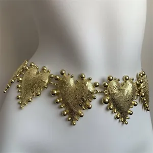 Detailansicht eines luxuriösen vergoldeten Metallherz-Kettenbügels mit strukturiertem Perlendesign.