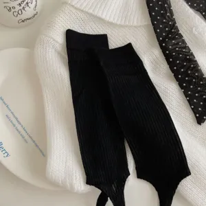 Black ribbed stirrup leg warmers detail shot, lightweight summer style close up view.