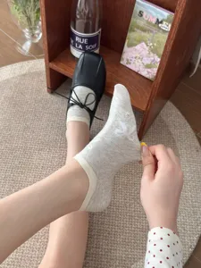 Nahaufnahme von leichten Baumwollsocken mit einem charmanten Schleifenmuster im Detail.