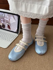 Nahaufnahme koreanischer Ballett-Netz-Socken kombiniert mit hellblauen flachen Schuhen.