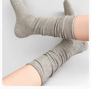 Graue Slouch-Socken Detail, weiche gestrickte lange Socken, bequeme Winterkleidung.