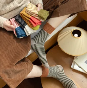 Detailansicht dicker gestreifter Baumwollsocken im gemütlichen College-Stil mit farbigen Akzenten.