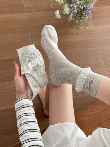 Cute grey mesh mid-calf socks with delicate white lace trim and sweet bows for women.