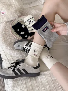 Detailed close-up view of women's cute cartoon sheep embroidered striped mid-calf socks.