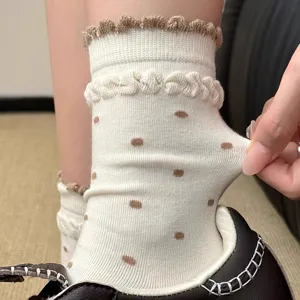 Close-up detail shot of cute white women ruffle polka dot mid-tube socks for autumn daily.