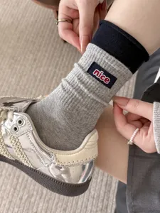 Women grey ribbed mid-calf socks with contrast black cuff and nice embroidery detail.