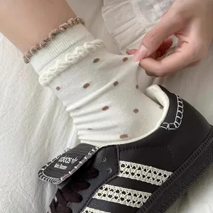 Cute white mid-calf socks with brown polka dots, ruffles and twisted knit cuff for women.
