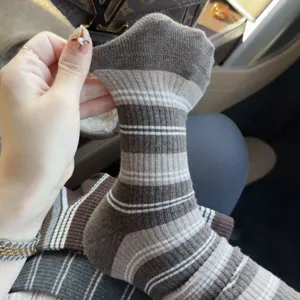Detailaufnahme braun gestreifter Strickstrümpfe mit elastischem Bündchen für die Herbstsaison.