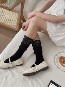 Women black mid-tube socks with delicate lace ruffle trim, stylish daily footwear accessory.