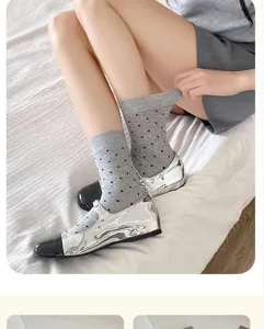 Detailed close-up showing stylish grey mid-tube socks with charming black polka dot designs.
