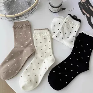 Close-up detail of cute Japanese retro polka dot women socks with ruffled lace cuffs, autumn winter.