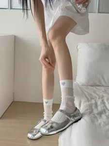 Detailed close-up of breathable sheer mesh mid-calf socks featuring cute heart embroidery.