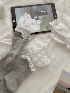 Detailed closeup of grey women mid-tube socks featuring delicate white lace ruffle trim.