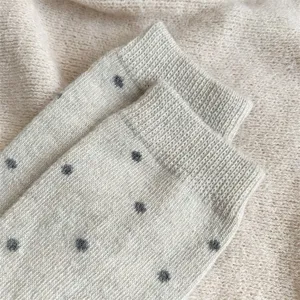 Detailansicht gemütlicher dicker Winter Strick Socken mit Punkten in hellem Beige.