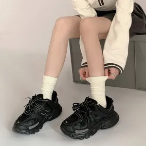 Weisse mittelhohe Socken fuer Damen kombiniert mit schwarzen klobigen Freizeitschuhen.