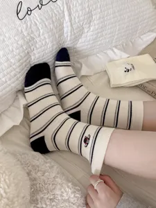 Detailed close-up of Korean style striped crew socks with cute cartoon sheep embroidery design.