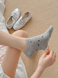 Detailed view of grey low-cut cotton socks with cute floral patterns, breathable and thin.