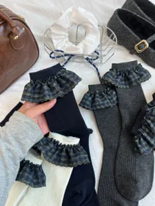 Vue détaillée de chaussettes pour femmes avec adorables poignets à volants à carreaux marine.