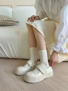 Close-up detail of cozy cable knit mid-tube socks paired with thick-soled casual canvas shoes.