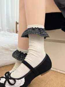 Gros plan de chaussettes mi-mollet à carreaux et volants doux avec bordure en dentelle.