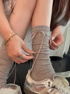 Detailed shot of grey ballet core crew socks featuring delicate ribbon tie for women.