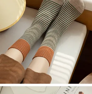 Nahaufnahme dicker gestreifter Baumwollsocken mit warmen farbblockierten Bündchen im Winter.