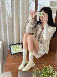 Detailed view of light green mid tube socks with delicate mesh and sweet lace ruffle trim.