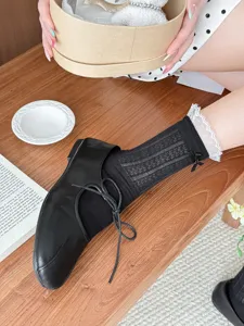 Black mesh mid-calf socks featuring delicate lace trim and cute bow detail for women