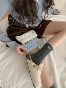 Cozy thick knit crew socks for women, stylish warm winter footwear accessory with cute label.
