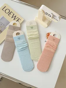 Detailed shot of pastel ribbed slouch socks with cute heart embroidery, aesthetic style.