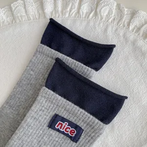 Women ribbed mid tube slouch socks with navy blue rolled cuff and nice embroidered label.