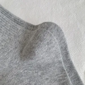 Detailed view of soft grey knitted fabric socks, showing fine texture and comfortable weave.