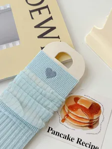 Close-up of light blue mesh slouch socks with cute heart embroidery, sweet college style detail.