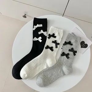 Women's sweet mid-tube socks featuring cute bow decorations, solid knit basic design.