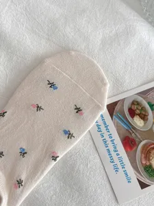 Detailed shot of beige low-cut boat sock featuring delicate woven floral pattern for summer wear.