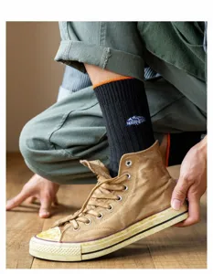 Herren dicke schwarze gerippte lange Socken mit orangem Rand und Berg Stickerei Design.