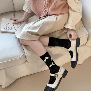Close-up of sweet black mid-calf socks featuring cute white bows and Mary Jane shoes.
