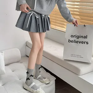 Sweet grey mid-calf socks featuring cute black bow details, perfect for cute daily footwear styling.
