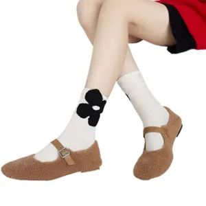 Cute fuzzy Mary Jane flat shoes paired with chic floral mid-tube socks for women.