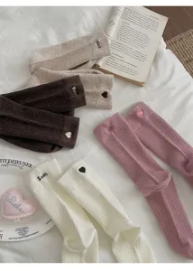 Close-up detail of Korean style ribbed cotton mid-tube socks with cute heart and letter embroidery.